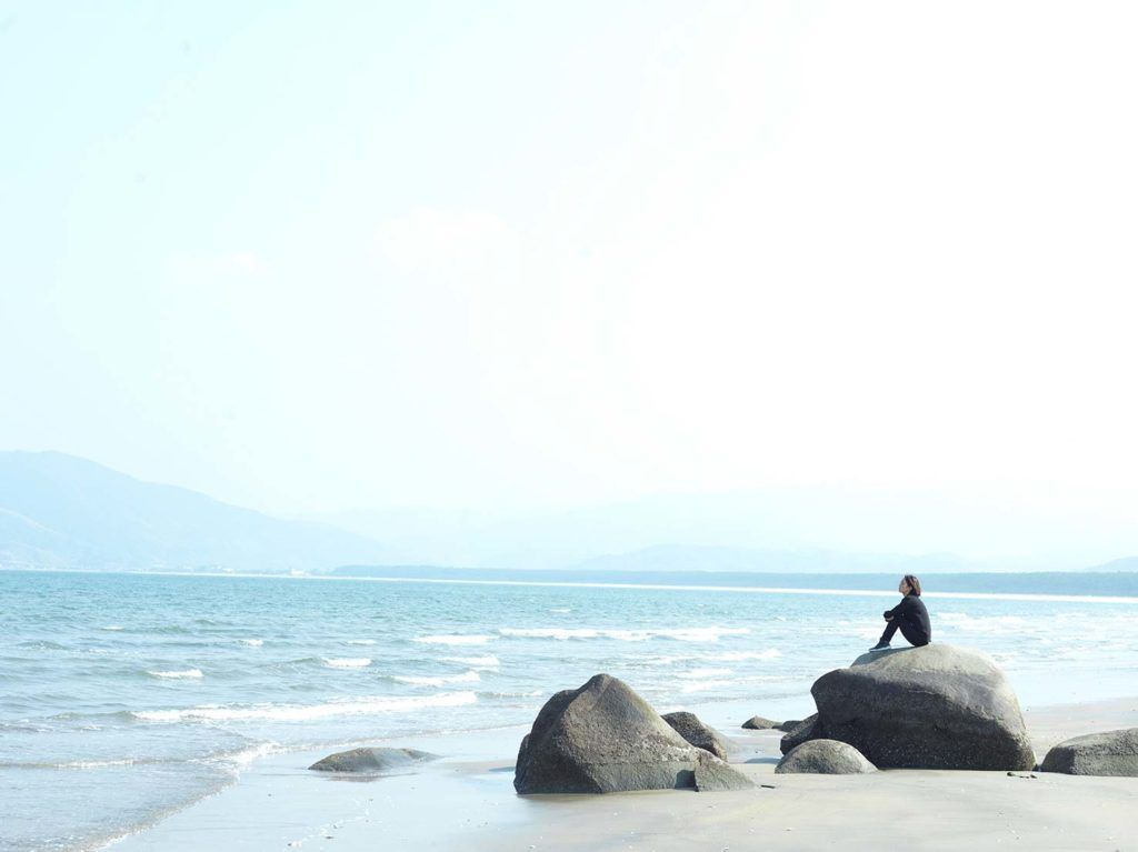 Satoko sitting by the beach