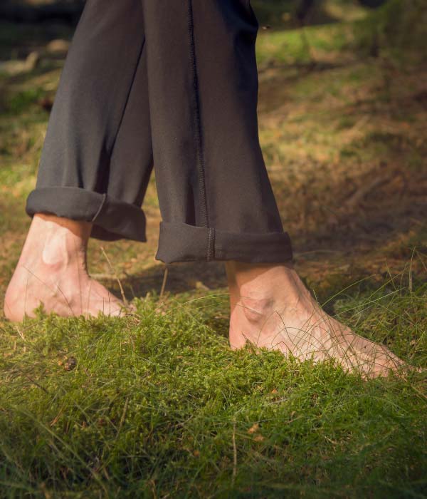 A man walking barefoot on grass