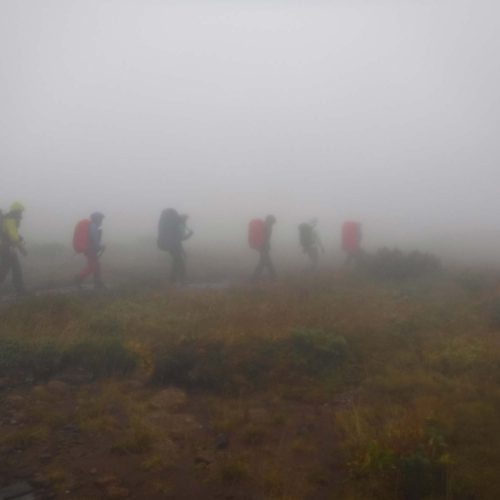Adventures of hikers walking through fog